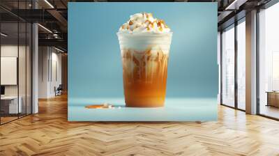 Iced caramel latte with whipped cream in plastic cup. Ad for cold coffee. Sky blue background. Summer drink concept. Wall mural