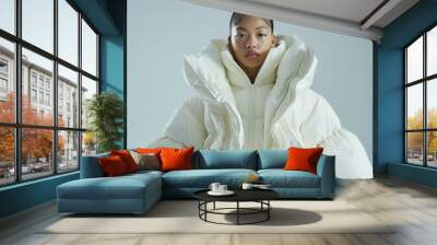 Young woman in oversized white puffer jacket, stylish winter fashion, modern cold weather outerwear Wall mural