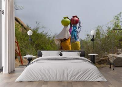 two indian women carry water on their heads in pots Wall mural