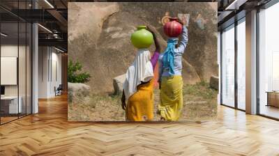 two indian women carry water on their heads in pots Wall mural