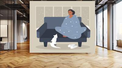 vector illustration in a flat style - a girl in a sofa wrapped in a blanket next to her heater. winter outside Wall mural