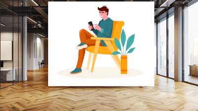 A man uses a smartphone while sitting on a yellow chair. Guy holding smartphone and spending time online. Vector illustration in flat style. Wall mural