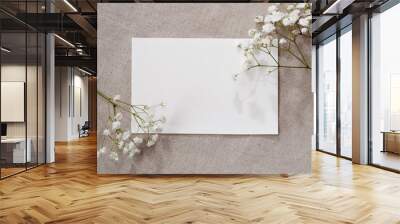 Blank paper card and gypsophila flowers on neutral beige linen texture background, aesthetic floral greeting card or wedding invitation template with copy space Wall mural