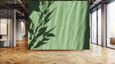 Bright green summer or spring natural background with copy space, aesthetic sun light floral leaves shadows on green textile backdrop Wall mural