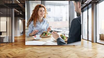 Businesspeople having business lunch at restaurant sitting eating salad drinking espresso talking cheerful Wall mural