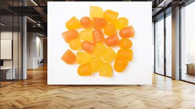 Close-up texture of orange and yellow multivitamin gummies on white background.  Healthy lifestyle concept. Wall mural