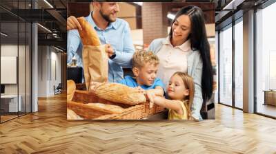 Daily Shopping. Family of four in the supermarket children taking bread greedy smiling happy Wall mural