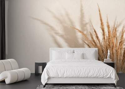 Dried meadow grass bouquet and elegant sun light shadows on beige wall background, aesthetic summer backdrop, copy space Wall mural