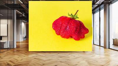 Large ripe strawberries on a yellow background. Ugly fruits, berries Wall mural