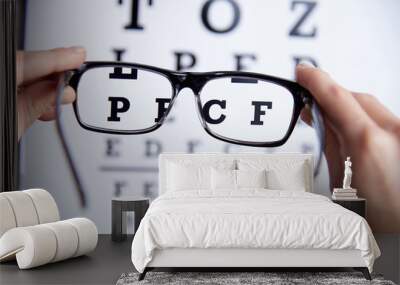 Glasses in the hands on the background of the table for vision Wall mural