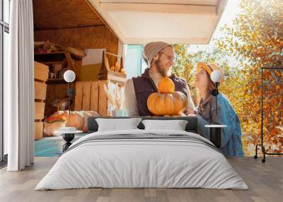 Halloween Preparaton Concept. Young couple decorating house with pumpkins looking at each other happy Wall mural