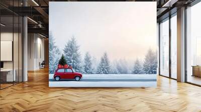 A small red car traveling along a winter road covered in snow, adorned with a Christmas tree on its roof and surrounded by colorful gift boxes in the forest Wall mural