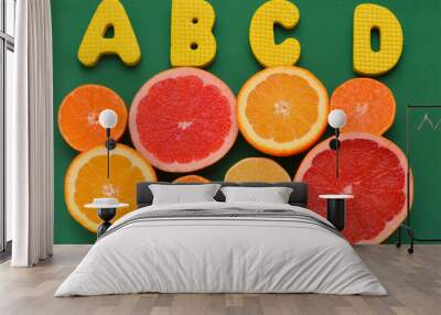 slices of citrus fruits and the letters A, B, C, D means the vitamins they contain Wall mural