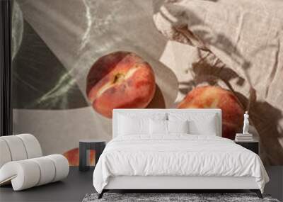 Ripe peach fruits on neutral beige tabletop, linen tablecloth, aesthetic floral sunlight shadow. Elegant sustainable lifestyle background, healthy vitamin food concept Wall mural