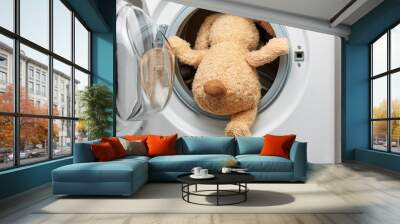 Stuffed toy rabbit with his back in the washing machine. Wall mural