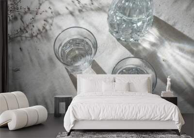 Two glasses with alcohol drink and bottle on table with aesthetic sunlight shadows, top view, lifestyle Wall mural