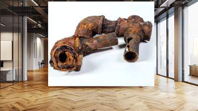 Fragments of old cast-iron water pipes on white background. After many years of operation corroded metal pipe was destroyed. Rusty steel tube with holes of metallic corrosion. Rusty cast iron, metal Wall mural