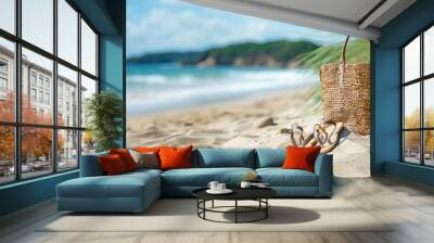 Woven straw tote bag and flip-flops on sandy beach with azure sea and distant cliffs in soft focus Copy Space Wall mural