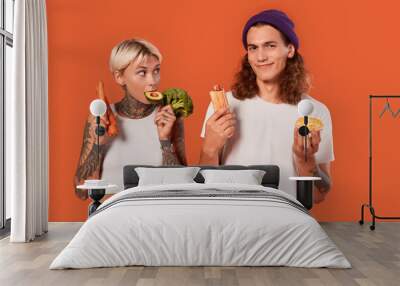 Young adult boyfriend and girlfriend with different food Wall mural