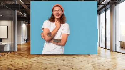 Young adult guy laughing and looking at camera Wall mural