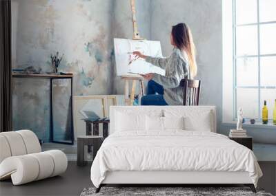 Young woman artist painting at home creative painting back view Wall mural