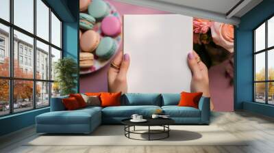 Blank notebook sheet in the hand for notes advertising menu in cafe with plates of macaroons, blank sheet of paper. Blank paper poster in male hands. Blank template for graphic designers portfolios Wall mural