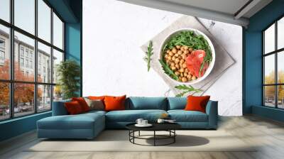 Bowl of healthy food: cooked chickpeas with fresh arugula and salmon fish Wall mural