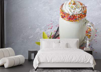 Crazy vanilla milk shake with whipped cream and colored sprinkles in glass jar Wall mural