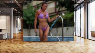 Fitness fashion model posing in lilac bikini in the swimming pool. Wall mural