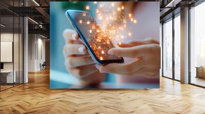 A close-up of a hand holding a smartphone with digital sparks and icons representing technology and innovation. Wall mural