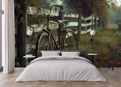 Vintage bicycle parked beside rustic wooden fence in atmospheric autumn setting Wall mural