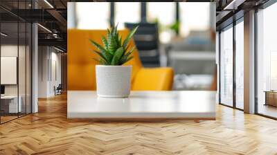 A stylish workspace featuring a small potted succulent on a white table, with a vibrant yellow chair and modern office furniture in the background. Wall mural