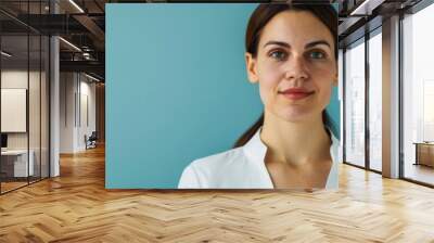 Confident woman with brown hair in a white blouse against a blue background, looking at the camera with a serene expression. Wall mural