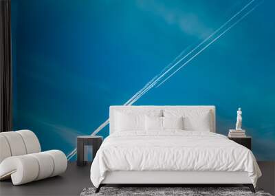 Airplane with contrail in the blue sky Wall mural