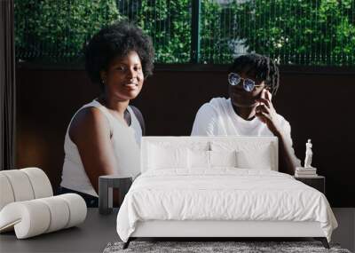 two happy African-American women communicate and laugh on the street in the summer Wall mural