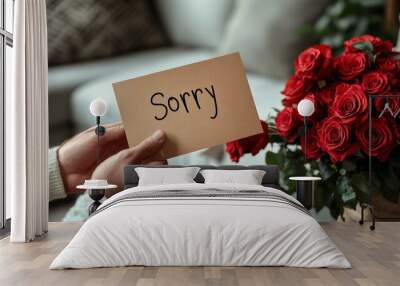 A person holds a card that says sorry, accompanied by vibrant red roses Wall mural