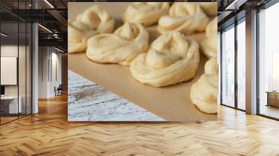 Close-up of raw yeast dough buns on baking paper on a wooden table. Wall mural