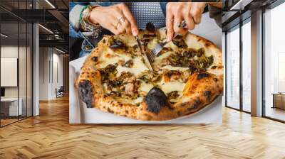 Pizza napoletana con salsiccia e friarielli mentre viene tagliata da un cliente con forchetta e coltello Wall mural