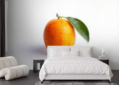 A single kumquat fruit with a green leaf on a white background. Wall mural