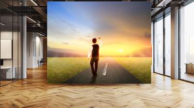 business man walking on highway road with morning sunrise Wall mural