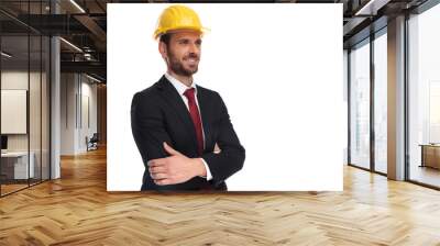 confident businessman wearing a yellow helmet looks up to side Wall mural