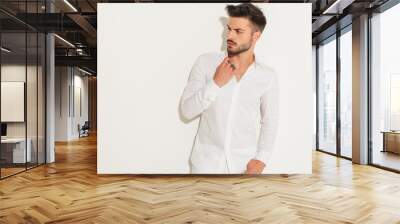 fashion man dressed in white fixing his collar Wall mural