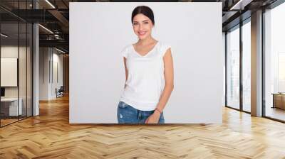 happy brunette woman wearing a white t-shirt standing Wall mural