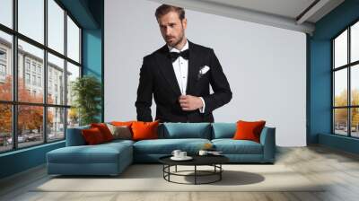 sexy elegant man wearing tuxedo and bowtie posing Wall mural