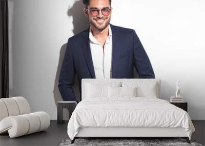 Smiling business man leaning on a white wall Wall mural