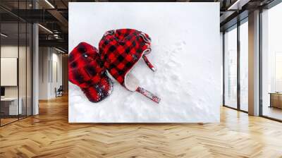 2 different classic red-black plaid pattern style head wears on the bright fluffy and soft snow, Winter woolen cloth accessory for the winter season. Top view with white copy space. Wall mural