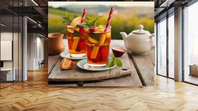 Two glasses of iced tea with mint and fruits on wooden table Wall mural