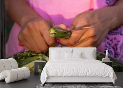 Young girl cutting okra lady finger with knife, preparing bhindi for cook Wall mural