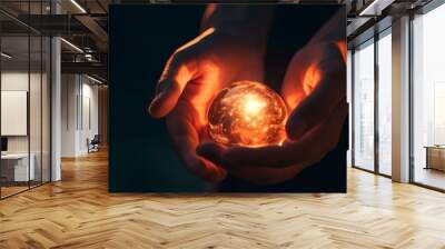 Closeup of hands holding a glowing orb in the darkness. Wall mural