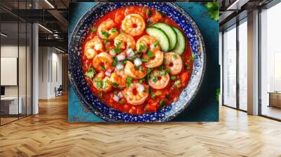 Mexican shrimp cocktail featuring fresh shrimp in a tasty tomato sauce accompanied by cucumbers onions lime juice and cilantro against a vibrant blue backdrop Wall mural